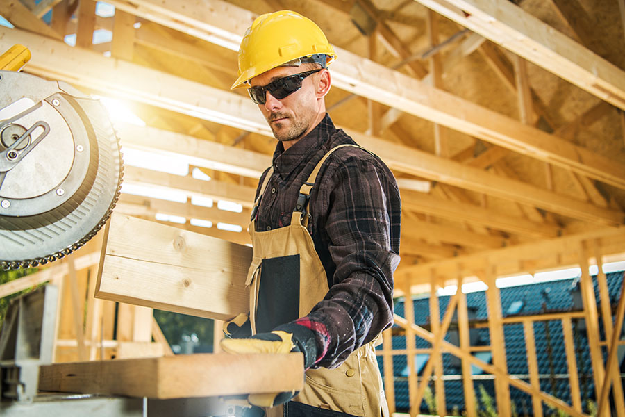 Specialized Business Insurance - Carpenter Preparing Some Wood to Cut to Use in a House Structure Project